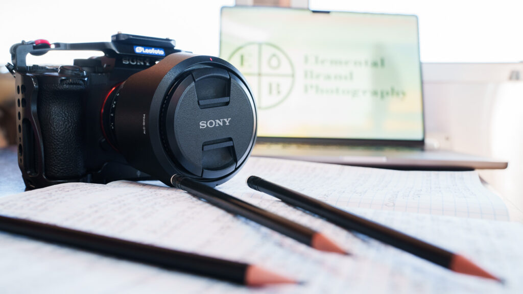 Camera, pencils and notepad, and computer of Elemental Brand Photography
