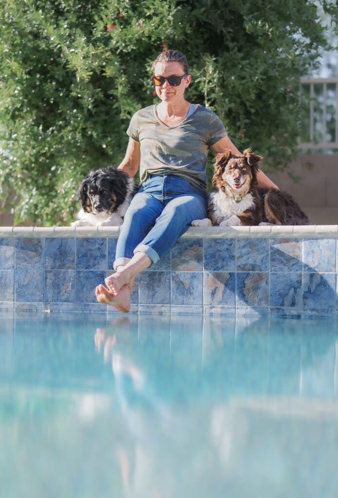 Two Visions. One Powerful Brand Story. 13 Debbie of Elemental Brand Photography relaxes by a pool after a photoshoot with her dogs Maizie and Layla