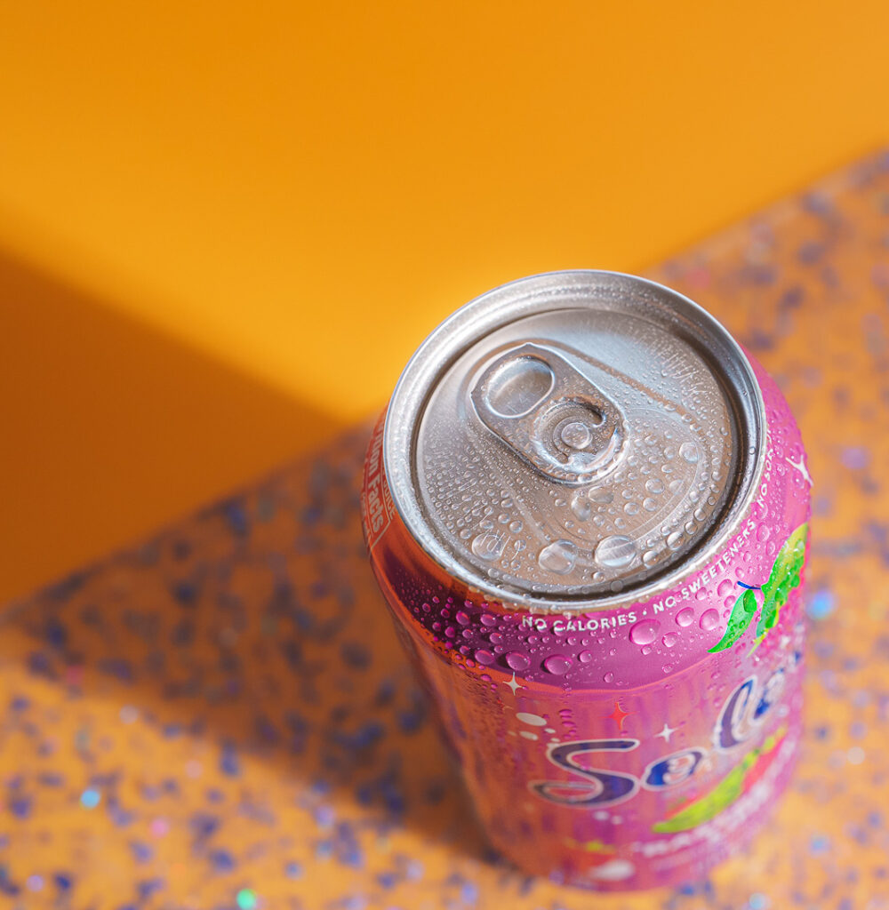 7 Ways a Brand Photoshoot Can Save You Time Creating Social Media Content 5 Top down look at pink Soleil can on orange background.
