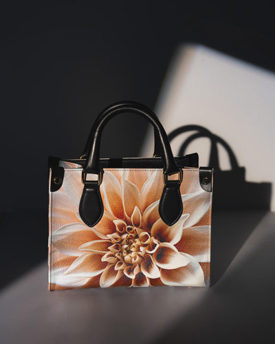 Purse sits on table with shadows highlighting the product