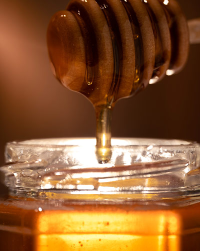 Seattle product photography - golden honey dripping off a honey dipper, Bees in the Burbs, Maple Valley WA