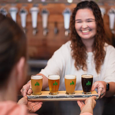 Seattle Restaurant Photography - Over-the-Shoulder Shot of Beer Flight Being Passed at North 47 Brewing Co. - Craft Brewery Story Telling - Tacoma, WA - Elemental Brand Photography