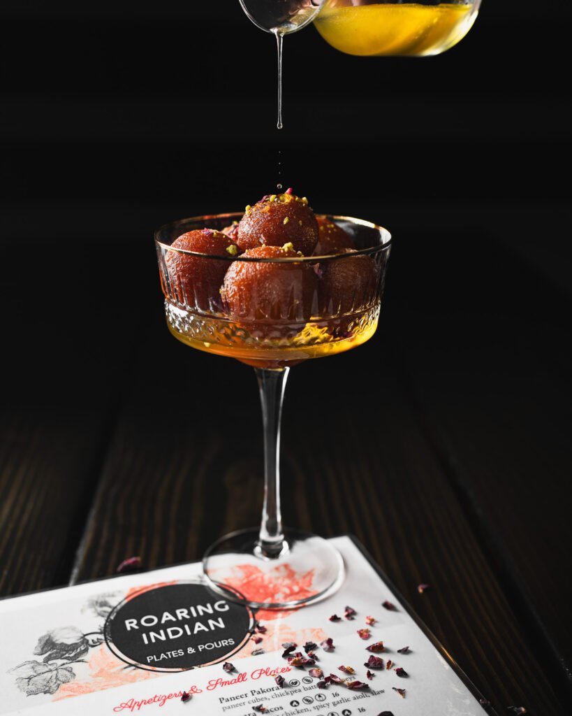 Seattle restaurant photography. Syrup drips onto a desert on the dish from a local indian restaurant.