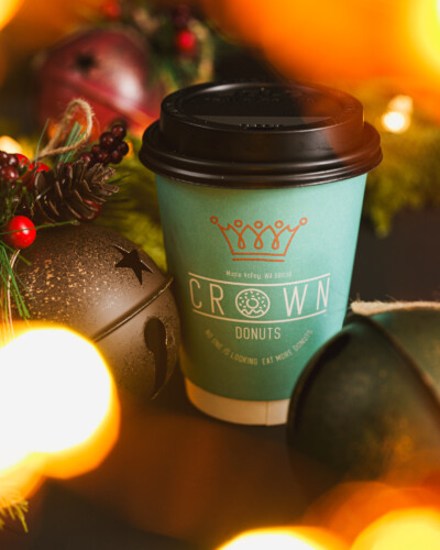 A simple, tightly-focused holiday image ties the brand to seasonal traditions, helping build a connection with the viewer and elevate the brand during the holiday season. Cup of Crown Donuts coffee sits amongst the ornaments of Christmas