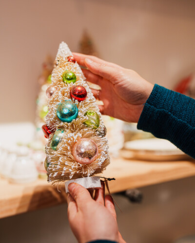 Showcasing the product in hand brings the brand to life, adding context, warmth, and engagement in a single frame. A unique christmas tree off the shelves at House & Hazel