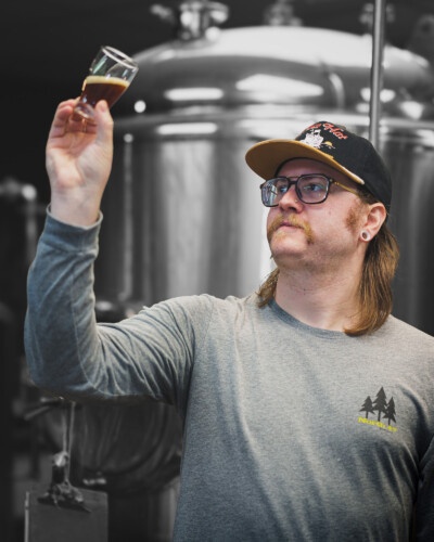 With the background muted to focus attention, this image captures the brewmaster’s quality check, reflecting the brand’s identity and commitment to excellence in every batch. North 47 brewmaster evaluates the quality of the beer once the brewing has completed