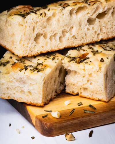 Bring your product to life by subtracting distracting background elements and focusing on the product through intentional lighting setups Detail photograph showing the textures and air pockets that create the thick and fluffy Peace Loaf Garlic Rosemary focaccia bread