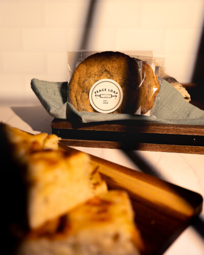 A scene can be elevated with the use of light, much like in this scene where a warm light with a window texture gives the illusion of a stack of cookies on a morning counter, Warm light comes through a window highlighting a stack of Peace Loaf cookies in a tray