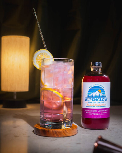 Seattle Product Photography for Alpenglow Cocktail Company in Issaquah. Fresh ingredients bring life to a sparkling water refreshment in a moody setting - evergreen social media content for a popular pacific northwest based brand. Seattle Product Photography - huckleberry lemondrop mocktail mixed with fresh lemon and sparkling water - Alpenglow Cocktail Company - Issaquah, WA - Elemental Brand Photography