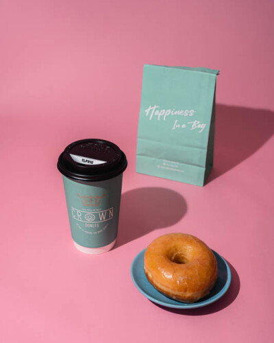 Seattle Product Photography for Crown Donuts in Maple Valley, WA - fresh glazed donut in direct light with well defined shadows - social media content for a small business in the local community Seattle Product Photography - Crown Donuts Maple Valley, WA - Glazed donut, coffee, and go-bag - Elemental Brand Photography
