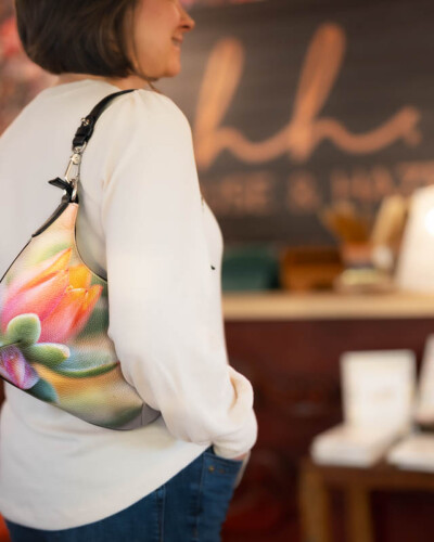 Seattle brand photography for Sally's Blooming Bags in Maple Valley, WA. A person carries a floral tote into House & Hazel in Maple Valley - in-context lifestyle imagery showing how this Pacific Northwest artisan bag brand fits naturally into a local community day. Seattle Brand Photography - Person Carrying Sally's Blooming Bags Floral Leather Mini-Curve Tote into House & Hazel - Maple Valley Local Brand Lifestyle - Sally's Bags - Maple Valley, WA - Elemental Brand Photography