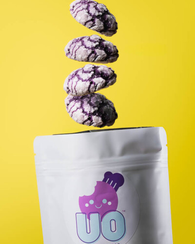Seattle product photography for Ube Overload in Maple Valley, WA. A multi-shot composite image creates the illusion of vibrant purple ube crinkle cookies raining down into their branded packaging - playful, scroll-stopping social media content for a Pacific Northwest artisan dessert brand. Seattle Product Photography - Multi-Shot Composite of Ube Crinkle Cookies Falling Into Branded Packaging - Ube Overload - Maple Valley, WA Elemental Brand Photography