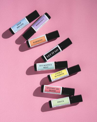 Seattle product photography for Wild Grove Essentials. Eight aromatherapy roll-on scents displayed with intentional shadows on a soft bubblegum pink backdrop - evergreen product collection imagery for a nature-inspired wellness brand. Seattle Product Photography - Wild Grove Essentials Eight-Scent Essential Oil Roll-On Collection on Pink Backdrop - Pacific Northwest Wellness - Maple Valley - Elemental Brand Photography