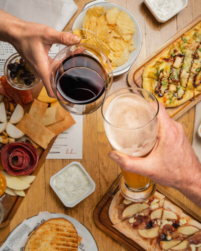 Seattle restaurant photography for House & Hazel in Maple Valley, WA. Drinks and plated starters and shareables together on the table capture the full dining experience of the perfect meetup space - food and beverage photography for a Pacific Northwest destination that pairs elevated cuisine with thoughtful design. Seattle Restaurant Photography - House and Hazel Drinks and Food Plates on Table - Maple Valley Bar and Lunch Restaurant - Maple Valley, WA - Elemental Brand Photography